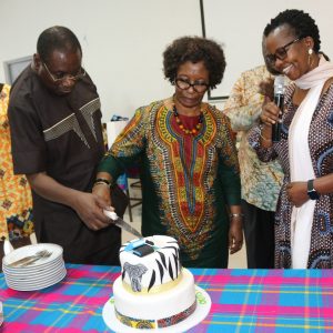 Prof.-Elegwa-Mukulu-is-assisted-to-cut-a-cake-by-his-wife-during-his-Farewell-ceremony.-Looking-on-is-scaled Prof. Mukulu: Three Decades of Illustrious Service to JKUAT
